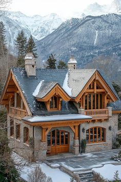 a large house in the mountains with snow on the ground