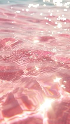 the water is pink and blue with some bubbles on it's surface, as well as sunlight