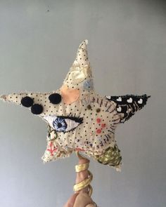 a hand holding up a decorative star ornament