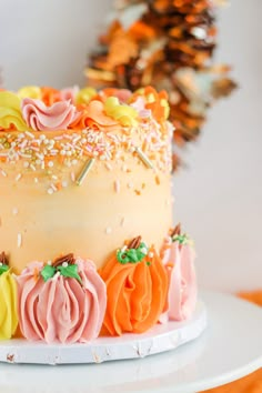 a cake decorated with frosting and pumpkins on a plate