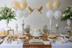 a table topped with lots of desserts and balloons