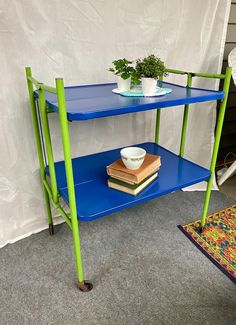 a blue table with green legs and a plant on top