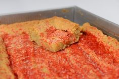 a close up of food in a pan with red stuff on the top and bottom