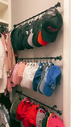 there are many hats and pants hanging on the wall next to each other in this closet