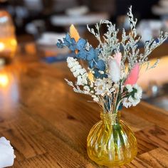 a glass vase with flowers in it sitting on a table