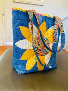 a blue bag with yellow and white flowers on the front is sitting on a table