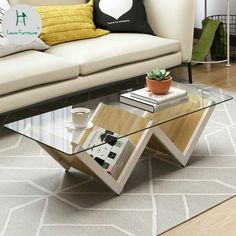 a living room with a couch, coffee table and books on the floor in front of it