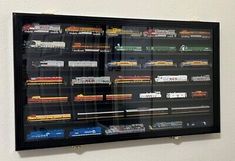 a wall mounted display case with trains on it's sides and train tracks in the middle