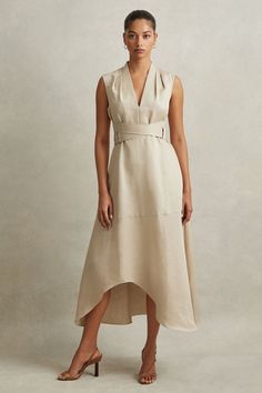 Find REISS Ava Linen Lyocell Strappy Midi Dress on Editorialist. Inspired by a corsetry aesthetic, the Ava midi dress cinches at the waist with adjustable belt straps. It's lustrous linen-lyocell fabric and tactful shoulder pleats maintain a confident look. Linen-lyocell blend. V-Neckline. Pleats to shoulder. Adjustable belt straps. Side pockets. Zip-closure to side. Dipped midi length. The model is wearing a size 8 Going Out Trousers, Strappy Midi Dress, Business Chic, Linen Loungewear, How To Iron Clothes, Dress Shapes, Mid Length Dresses, Clothing Care, Adjustable Belt