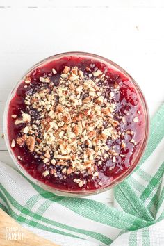 a bowl filled with cranberry sauce on top of a green and white towel