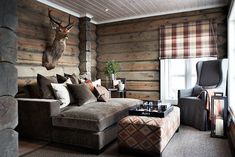 a living room filled with furniture and a deer head mounted to the side of the wall