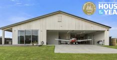 an airplane is parked in the garage of a house that has been built for sale