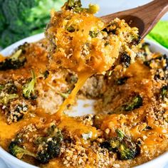 broccoli casserole with cheese being lifted from the casserole dish