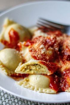 a white plate topped with ravioli covered in sauce