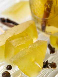 two pieces of pineapple sitting on top of ice next to some raisins