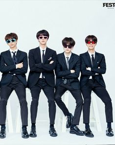 four young men in suits and sunglasses posing for a photo with their arms crossed,