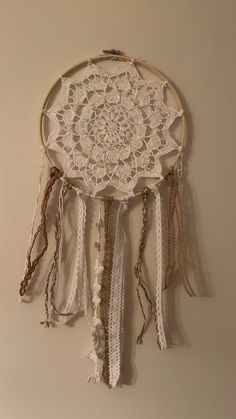 a white dream catcher hanging on the wall