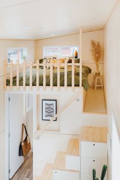 there is a loft bed in the middle of this room with stairs leading up to it