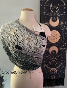 a crocheted shawl is displayed on a mannequin's head