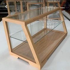 a wooden display case with glass shelves on top