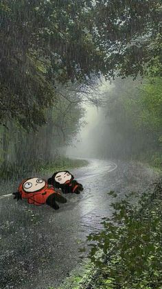 two people are laying on the road in the rain with umbrellas over their heads