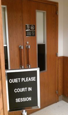 a court room door with a sign in front of it that says quiet please court in session