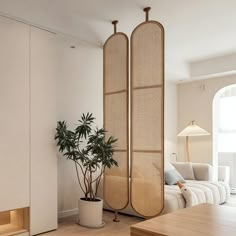 a living room filled with furniture and a potted plant on top of a wooden table