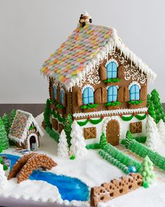 a gingerbread house is decorated with icing and snow on the roof, along with other decorations