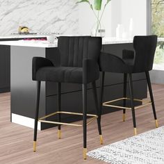 two grey velvet bar stools with gold legs in front of a kitchen countertop