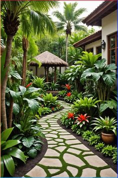 a garden with lots of tropical plants and flowers on the path to an outside room