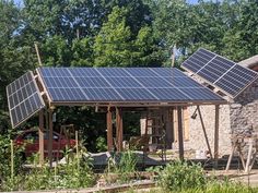 a house with solar panels on the roof and some trees in the backgroud