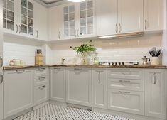 a kitchen with gray cabinets and white tile flooring