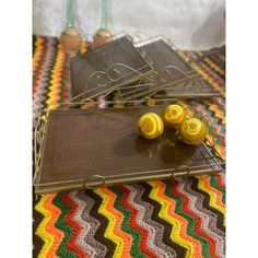 two yellow knobs sitting on top of a wooden tray next to a crocheted blanket