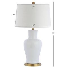 a white table lamp with a gold base and a light shade on the bottom side