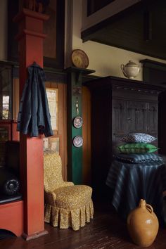 a chair and table in a room with wooden flooring, walls and ceiling decorations