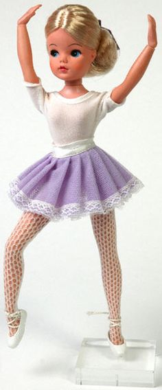 the doll is wearing a purple and white dress with tights on it's legs