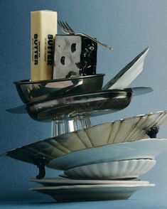 a stack of plates with knives and forks on top of each other in front of a blue background