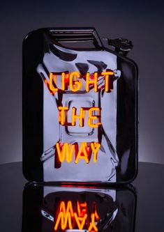 a black suitcase with the words light the way written on it in neon orange letters