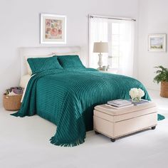 a bedroom with white walls and blue bedspread