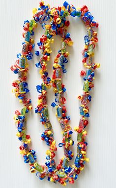 a multicolored beaded necklace is displayed on a white surface