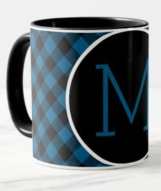 a black and blue plaid pattern with the letter m coffee mug