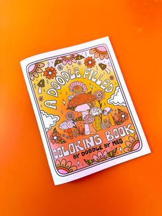 the coloring book is on an orange surface