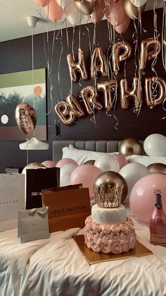 a birthday party with pink and gold balloons, champagne bottles, and cake on a bed