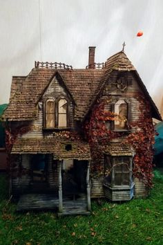 an old house with ivy growing on it's roof and windows is shown in front of a tent