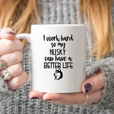 a woman holding a coffee mug with the words i work hard so my husky can have a better life