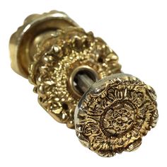 an ornate gold door handle on a white background