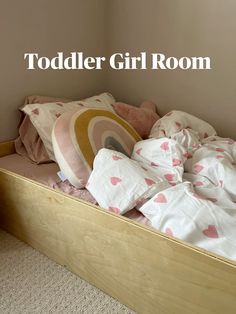 an unmade bed with pink and white sheets on it, next to the toddler girl room