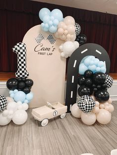 balloon arch with cars and checkered balloons on the front for a first birthday party