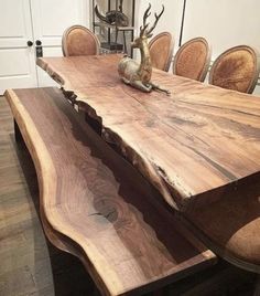 a wooden table with chairs around it and an animal figurine on the top