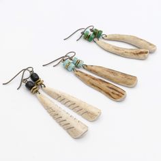 three pairs of wooden earrings with turquoise beads and beaded earwires on white background